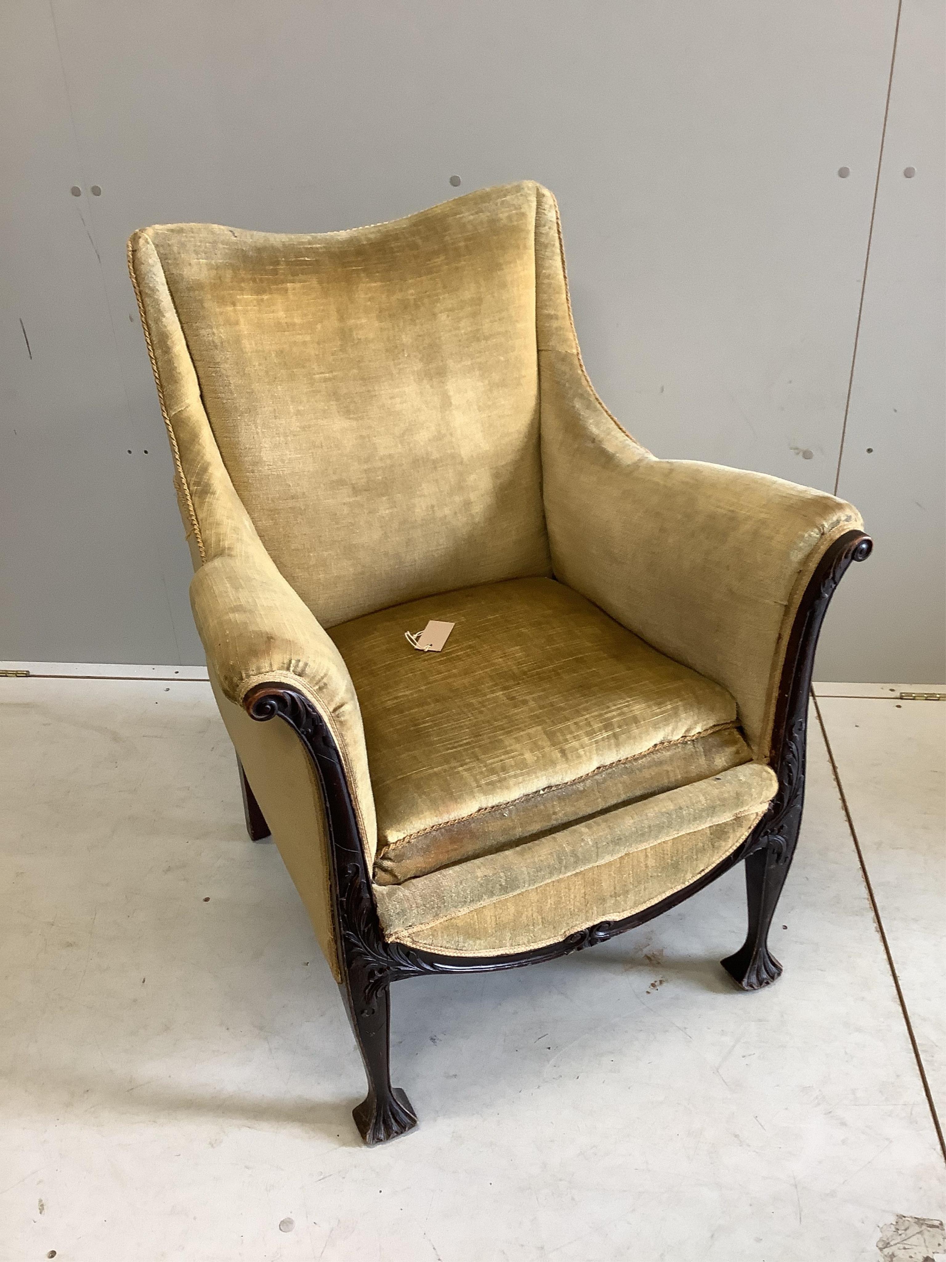 An Edwardian carved mahogany upholstered armchair, width 70cm, depth 61cm, height 91cm. Condition - fair, upholstery poor
